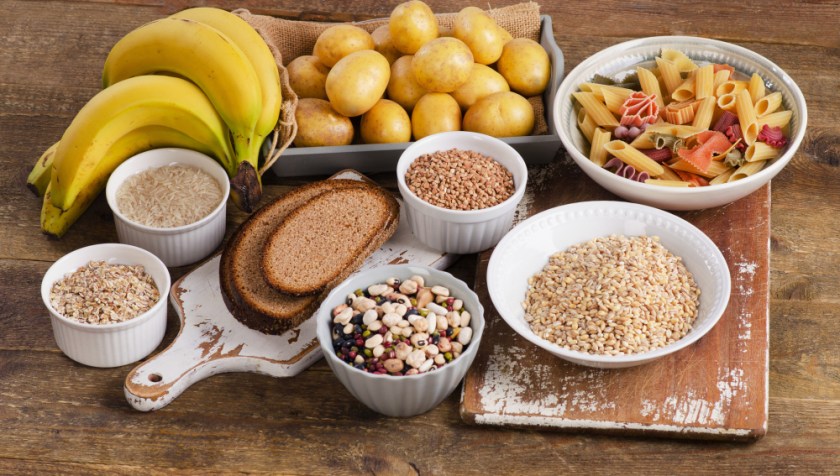 Foods high in carbohydrate on wooden background.